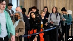 FILE - Travelers wait in line to board an Amtrak train ahead of the Thanksgiving Day holiday at 30th Street Station in Philadelphia, Nov. 23, 2022. 