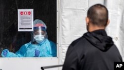 A member of the Brooklyn Hospital Center COVID-19 testing team calls on the next patient in line, March 26, 2020.