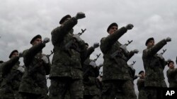 Romanian troops march during the national day military parade in Bucharest, Dec. 1, 2017. Key politicians didn't attend, signaling tensions between the president and the ruling left-wing coalition over plans to revamp the justice system.