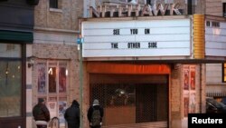 La gente camina por el cine Nitehawk, que estuvo cerrado debido a la pandemia, poco antes de que la orden del gobernador Andrew Cuomo "Estado de Nueva York en PAUSA" entrara en vigencia en Brooklyn, Nueva York, 22 de marzo 2020.