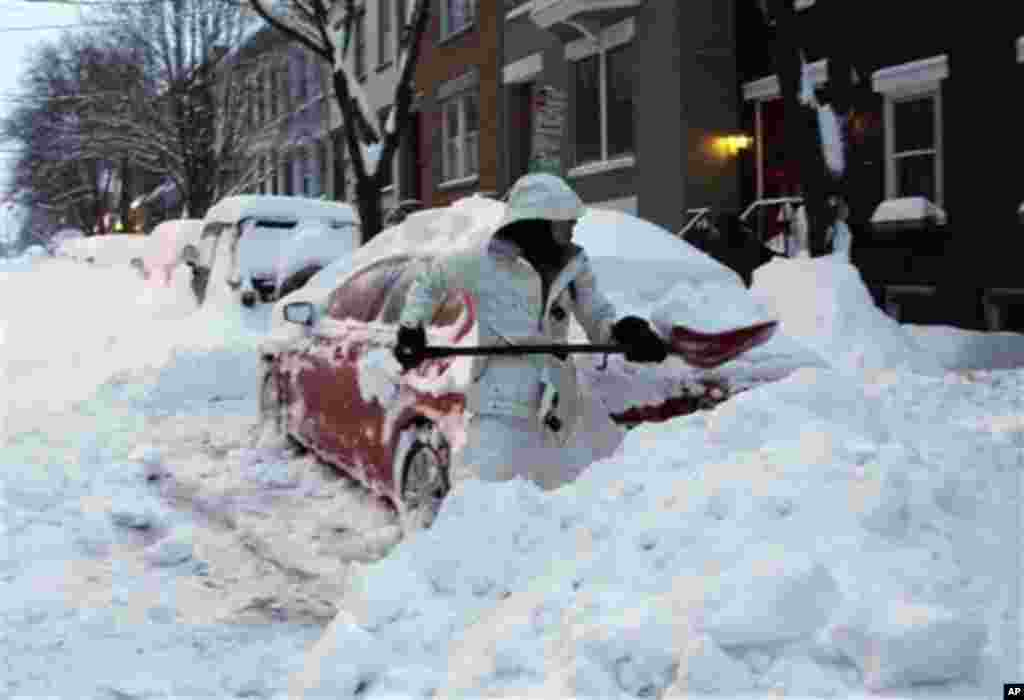 Liz Hall, of Albany, N.Y., digs her car out of snow in the Center Square neighborhood on Friday, Feb. 14, 2014, in Albany. Schools are closed across a swath of eastern New York from the mid-Hudson Valley to the Albany area as the region starts to dig out 