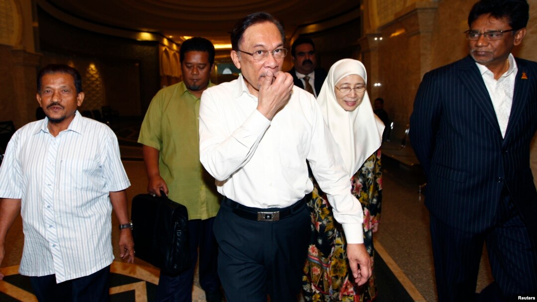 Nhà lãnh đạo đối lập Malaysia Anwar Ibrahim (giữa) và vợ đến tòa án ở Putrajava, Malaysia 7/3/14