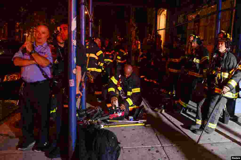 New York City firefighters stand near the site of an explosion in the Chelsea neighborhood of Manhattan, Sept. 17, 2016.