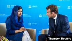 Nobel Peace Prize laureate Malala Yousafzai speaks to French President Emmanuel Macron on the sidelines of a G-7 ministers summit, in Paris, July 5, 2019.