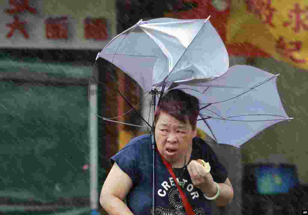 A woman in Taipei, Taiwan struggles with her umbrella against powerful winds from the typhoon Megi. Schools and offices have been closed in Taiwan and people have been removed from high-risk areas as the huge storm, with 162 kilometers-per-hour winds, nears the island.