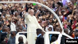 Pope Francis waves to the faithful as he arrives for a Mass in Kenya's capital, Nairobi, Nov. 26, 2015. 