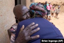 Emelyne Nzeyimana, right, and Prudencienne Namukobwa, perform akazehe outside her home in Ngozi, Burundi, Friday, Sept. 20, 2024. (AP Photo/Brian Inganga)