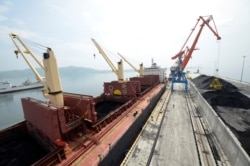 FILE - A cargo ship is loaded with coal at the North Korean port of Rajin, July 18, 2014.