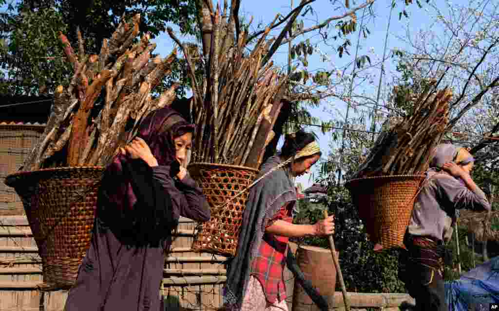 Naga women carry firewood as they walk home from a day in the field near Viswema village, in the northeastern Indian state of Nagaland.