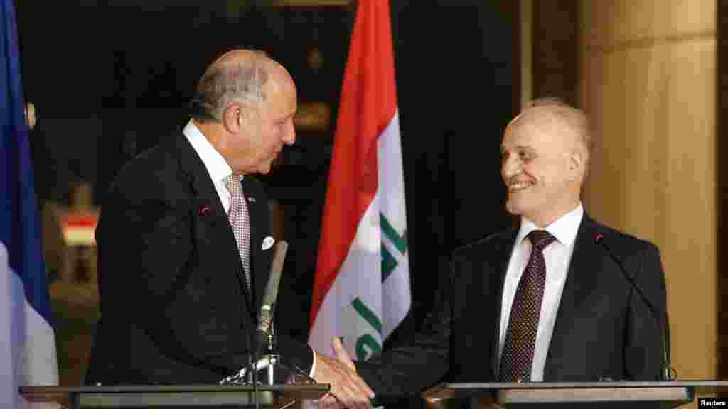 French Foreign Affairs Minister Laurent Fabius, left, shakes hands with Iraq's Deputy Prime Minister for Energy Hussain al-Shahristani after a news conference in Baghdad, Iraq, Aug. 10, 2014. 