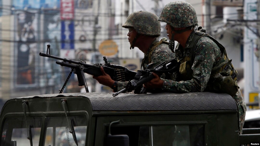 Dua orang tentara Filipina siaga dengan senjata mereka di atas truk militer saat memblokade jalan di kota Zamboanga, Filipina selatan (15/9). 