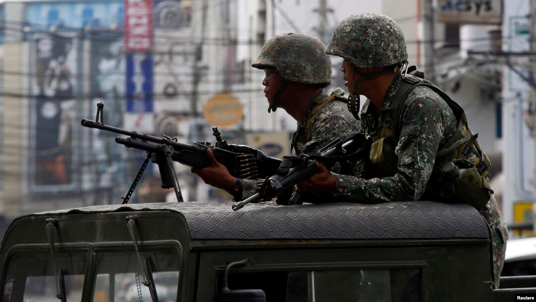 FILE - Members of the Philippine Marines hold their weapons in southern Philippines, Sept. 15, 2013.