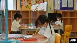 Siswa menggunakan sekat plastik untuk mencegah penyebaran Covid 19 di International Pioneers School di Bangkok. (Foto: AFP)