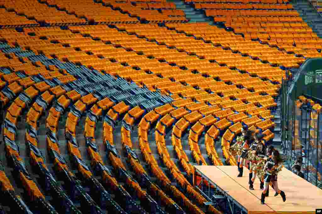 Cheerleaders perform to empty stands prior to an opening baseball game between the Yomiuri Giants and the Hanshin Tigers at Tokyo Dome in Tokyo.