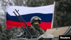 FILE - A Russian flag is seen behind a Russian army vehicle.
