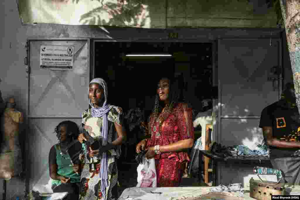 A customer picks up a skirt from her tailor in Dakar&#39;s Niary Tally neighborhood, the working class area where Dakar Fashion Week held their &quot;Street Show&quot; fashion show this year, June 29, 2017.