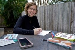 Kara McKlemurry poses for a photo while writing Thanksgiving notes to family and friends at her home, November 19, 2020, in Clearwater, Florida. On any normal Thanksgiving Day, McKlemurry and her husband would gather with family.