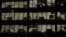 FILE - Workers are seen in office windows in the financial district of Canary Wharf in London, Nov. 3, 2015.   