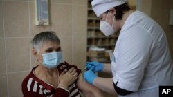 A medical worker administers a shot of Russia's coronavirus vaccine to an elderly woman in Korenovsk, Krasnodar region, 1,151 kilometers south of Moscow, Russia, Saturday, Nov. 13, 2021. 