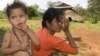 An ethnic minority Cambodian boy, left, stands next to his mother at a village, file photo. 