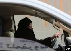 FILE - A woman drives a car on a highway in Riyadh, Saudi Arabia, March 29, 2014.