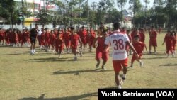 Ratusan anak-anak berlari merebut bola dari pemain sepak bola profesional dalam sepakbola kolosal perayaan Hari Anak Nasional di Solo, Senin (23/7). (Foto: Yudha Satriawan/VOA)