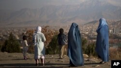 FILE - Afghan women with their children look at the view over Kabul, Afghanistan, Nov. 25, 2013.