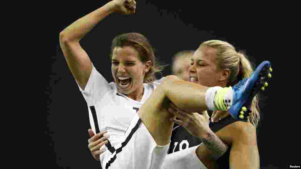 Tobin Heath (17) milieu de terrain de l’équipe américaine célèbre avec la gardienne de but Ashlyn Harris (18) après la victoire des Etats-Unis sur l'Allemagne (2-0) en demi-finale de la Coupe du Monde/Dames 2015 de la FIFA au Stade olympique, le 30 juin 2