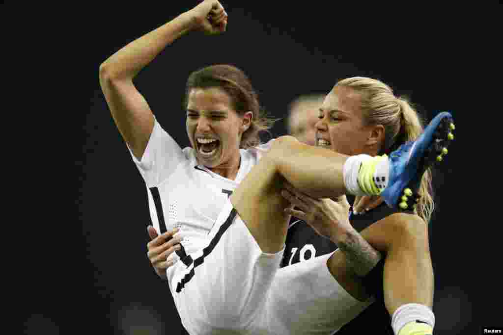Tobin Heath (17) milieu de terrain de l’équipe américaine célèbre avec la gardienne de but Ashlyn Harris (18) après la victoire des Etats-Unis sur l'Allemagne (2-0) en demi-finale de la Coupe du Monde/Dames 2015 de la FIFA au Stade olympique, le 30 juin 2