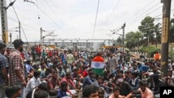 Protesters sit on railway tracks at Secundrabad railroad station in Hyderabad, India, June 17, 2022.