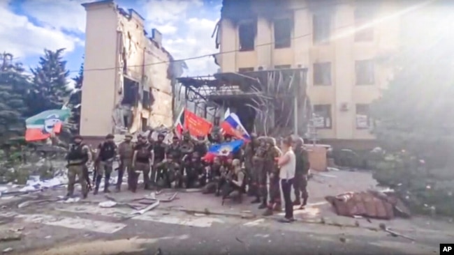 Foto e marrë nga një video e publikuar në kanalin zyrtar në Telegram të Ramzan Kadyrovit. Forcat ruse dhe ushtarët e regjimentit çeçen shfaqen përpara një godine të shkatërruar në Lysychansk, Ukrainë. (2 korrik 2022)