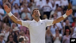 Arhiva - Srpski teniser Novak Đoković slavi nakon pobede nad Australijancem Nikom Kirjosom, na teniskom šampionatu u Vimbldonu, 10. jula 2022.