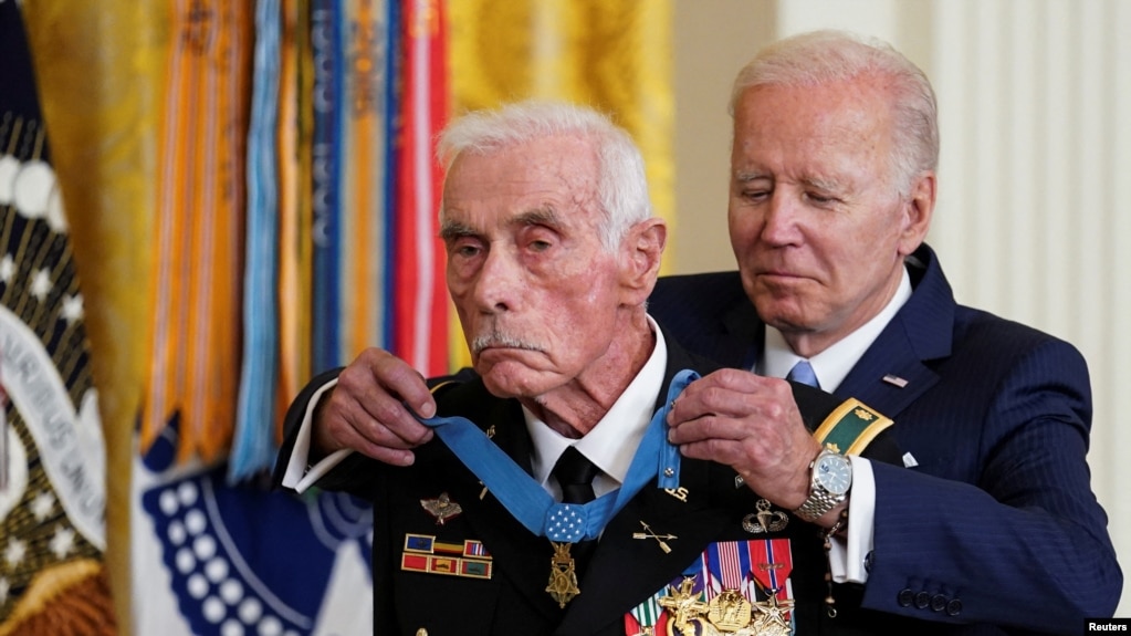拜登总统在白宫为退役美国陆军少校达菲戴上荣誉勋章。（2022年7月5日）(photo:VOA)