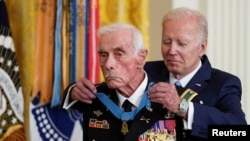 拜登总统在白宫为退役美国陆军少校达菲戴上荣誉勋章。（2022年7月5日）