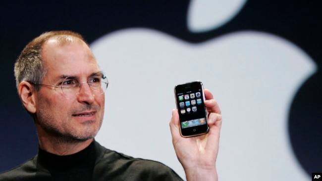 In this Jan. 9, 2007, file photo, Apple CEO Steve Jobs holds up an iPhone at the MacWorld Conference in San Francisco, California. (AP Photo/Paul Sakuma, File)