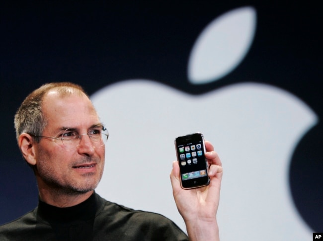 CEO Apple Steve Jobs mengangkat iPhone di Konferensi MacWorld di San Francisco, California. (Foto: AP/Paul Sakuma)
