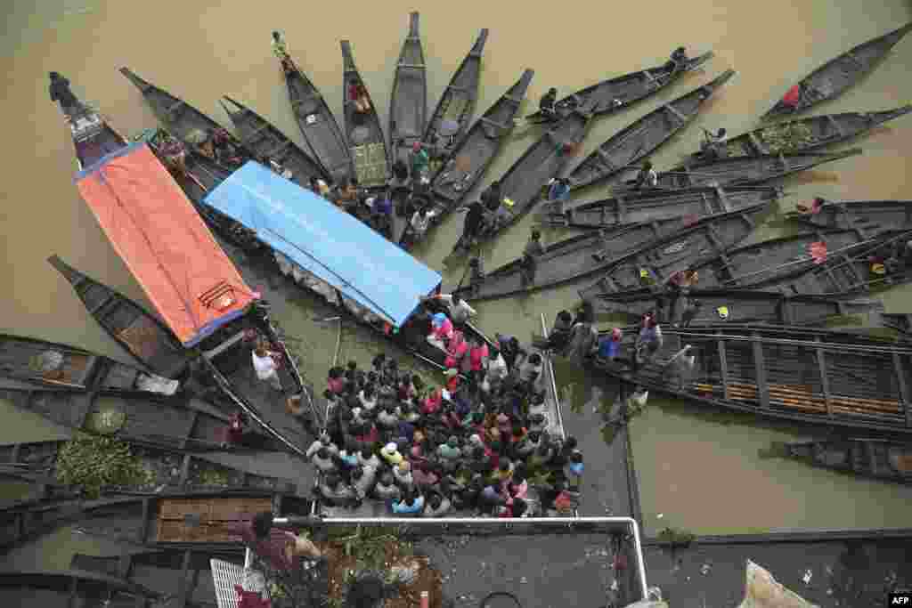 People gather to collect food aid in a flooded area following heavy monsoon rainfalls in Companiganj, Bangladesh.