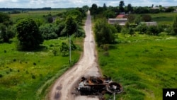 A ruined tank remains on a road in Lypivka, on the outskirts of Kyiv, Ukraine, June 14, 2022.