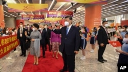 Presiden Xi Jinping dan sang istri Peng Liyuan menyapa para warga ketika tiba di stasiun kereta api di Hong Kong, pada 30 Juni 2022. (Foto: Xinhua via AP/Xie Huanchi)