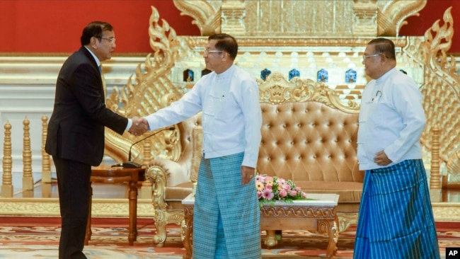 Myanmar State Administration Council Chairman Senior General Min Aung Hlaing, center, shakes hands with Cambodian Foreign Minister and ASEAN Special Envoy to Myanmar Prak Sokhonn, left, and Myanmar FM Wunna Maung Lwin, right, during a meeting in Naypyitaw, Myanmar, June 30, 2022.