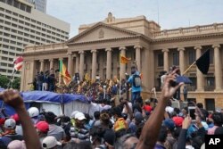 Protesters, many carrying Sri Lankan flags, gather outside the president's office in Colombo, Sri Lanka, July 9, 2022. Sri Lankan protesters stormed President Gotabaya Rajapaksa's residence and nearby office Saturday as tens of thousands of people took to the streets.