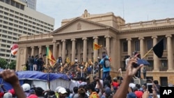 Protesters, many carrying Sri Lankan flags, gather outside the presidents office in Colombo, Sri Lanka, July 9, 2022. Sri Lankan protesters stormed President Gotabaya Rajapaksa's residence and nearby office on Saturday as tens of thousands of people took 