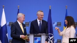 Finnish Foreign Minister Pekka Haavisto (L) shares a laugh with Swedish Ministry for Foreign Affairs Ann Linde (R) and NATO Secretary General Jens Stoltenberg (C) following a press conference at the NATO headquarters in Brussels, July 5, 2022. 