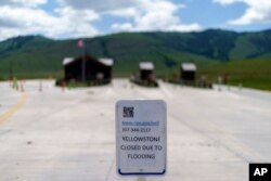 FILE - An entrance to Yellowstone National Park, a major tourist attraction, sits closed due to the historic floodwaters, in Gardiner, Mont., on June 15, 2022.