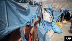 FILE - A child peeks from a tent at the internally displaced persons camp of Guyah, 100 kms from Semera, Afar region, Ethiopia, May 17, 2022.