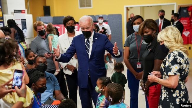 U.S. President Joe Biden greets children with first lady Jill Biden (right) at a COVID-19 vaccination clinic hosted by the District of Columbia's Department of Health at the Church of the Holy Communion in Washington, June 21, 2022.