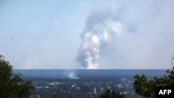 A picture taken on June 21, 2022 from the town of Lysychansk, shows a large plume of smoke rising on the horizon, behind the town of Sievierodonetsk, amid the Russian invasion of Ukraine. 