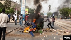 Protesters throw a dumpster on a fire in Dakar, Senegal, June 17, 2022. (Annika Hammerschlag/VOA)