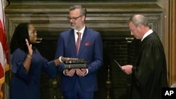 In this image from video provided by the Supreme Court, Chief Justice of the United States John Roberts administers the Constitutional Oath to Ketanji Brown Jackson as her husband Patrick Jackson holds the Bible at the Supreme Court in Washington, June 30, 2022.