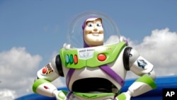 FILE - Character Buzz Lightyear stands near the entrance to the Aliens Swirling Saucers ride at Toy Story Land in Disney's Hollywood Studios at Walt Disney World in Lake Buena Vista, Fla., June 23, 2018.